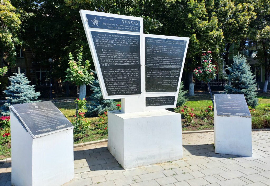 Памятный знак с приказом Верховного Главнокомандующего И. В. Сталина об объявлении благодарности войскам 3-его Украинского фронта, освободителям г. Бендеры от немецко-румынских фашистских захватчиков. Первый вариант стелы установлен в сквере Освобождения в 1967 году. Текст приказа увековечен в мраморе. В середине 80-х годов проведена реконструкция. В 1992 году стела была повреждена националистами Молдовы, в этом же году проведена новая реконструкция. Однако текст приказа был приведен не полностью, что вызывало нарекания ветеранов Великой Отечественной войны. В связи с этим в 2024 году состоялась третья реконструкция. Авторы – архитекторы Г. А. Райляну и Ф. К. Казаку. В приказе Сталина выносится благодарность войскам генерал-лейтенанта Гагена, генерал-майора Шкодуновича, генерал-майора Крузе, артиллеристам генерал-майора артиллерии Балаева, полковника Ковалева, летчикам генерал-полковника авиации Судец, отличившихся в боях за Бендеры. Под приказом стоит дата 23 августа 1944 года – дата освобождения г. Бендеры.